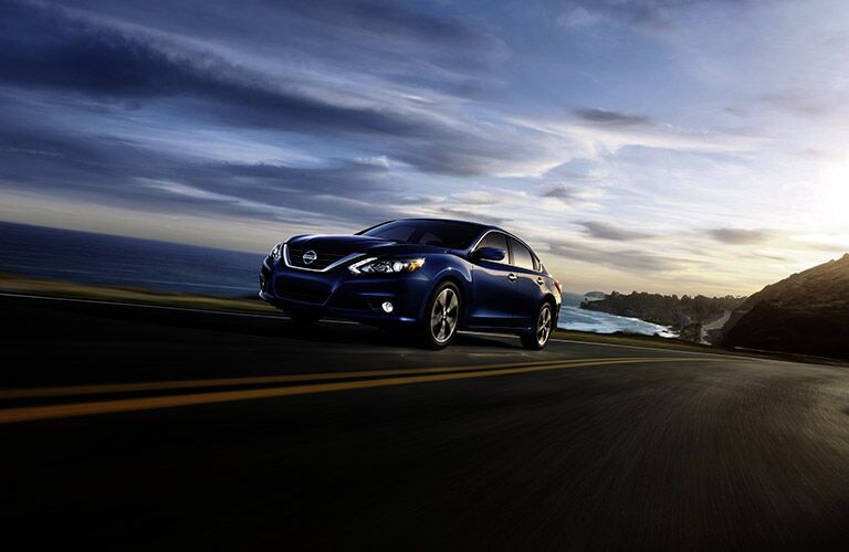 blue 2017 Nissan Altima driving along the coast