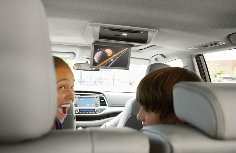 Passengers watching the rear seat entertainment display on the 2018 Toyota Highlander Hybrid