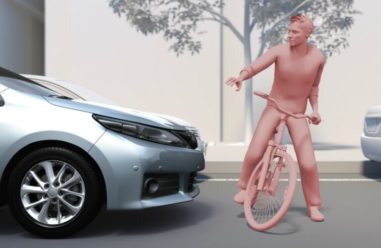 Toyota vehicle pausing for a person on a bike