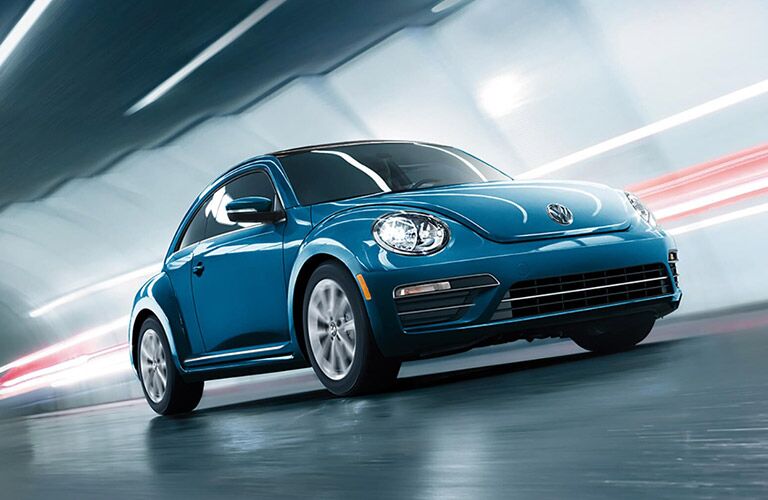 blue 2018 Volkswagen Beetle driving through tunnel