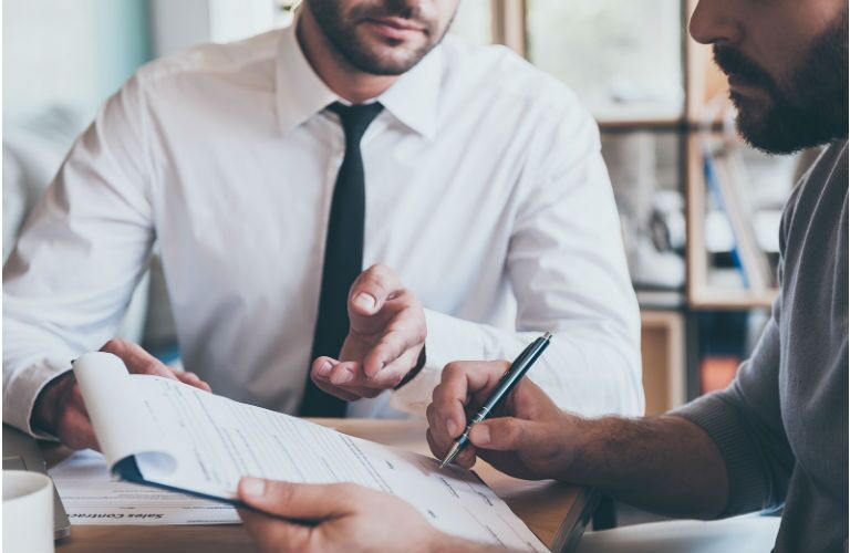 men doing paper work on purchasing a vehicle