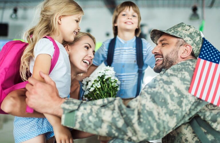 A member of the military is welcomed home by his family