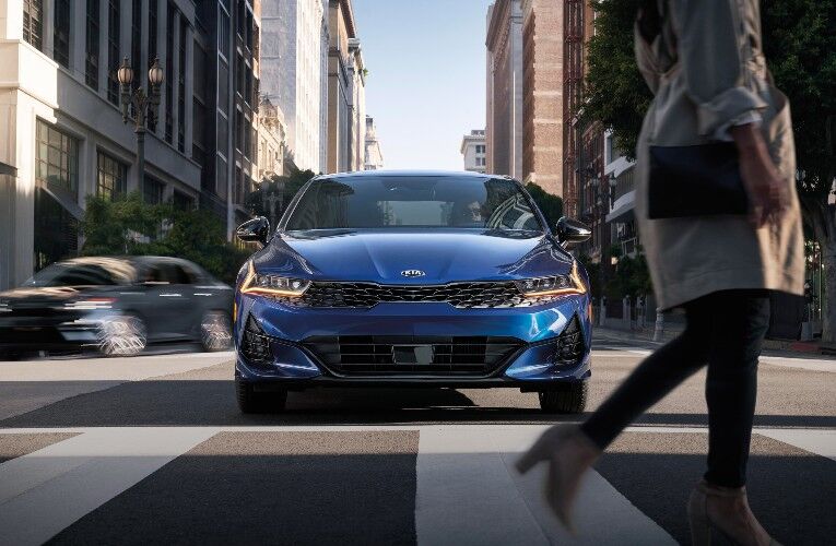 2021 Kia K5 at crosswalk with woman walking in front