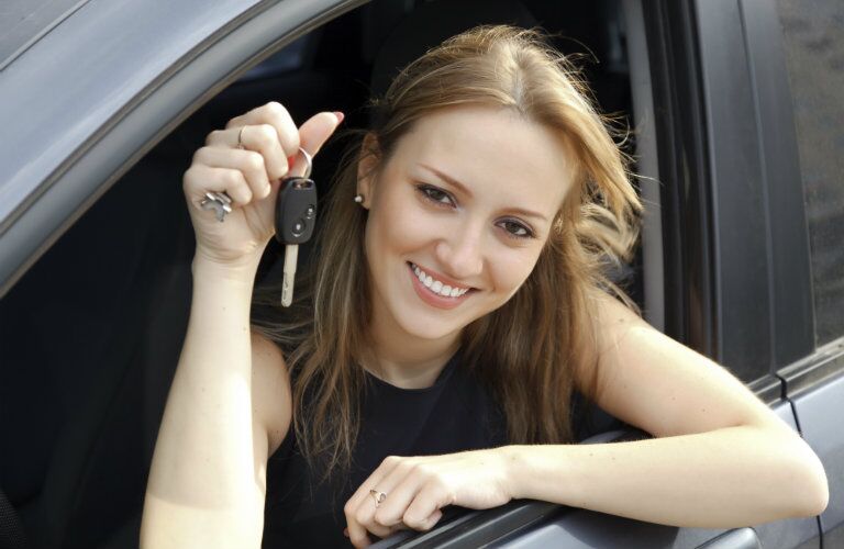 used car owner holding car keys out the window