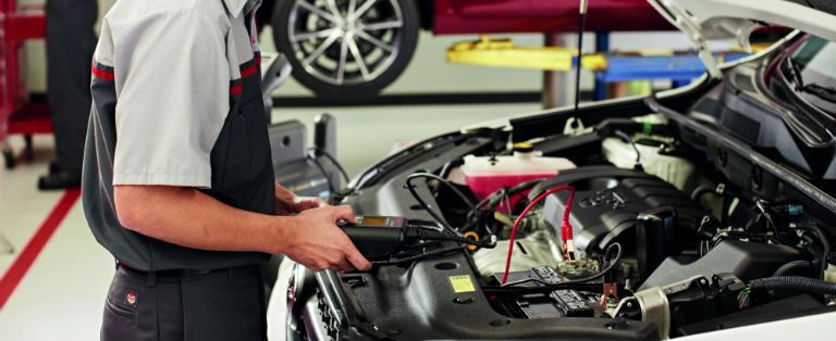 Toyota mechanic working on an engine
