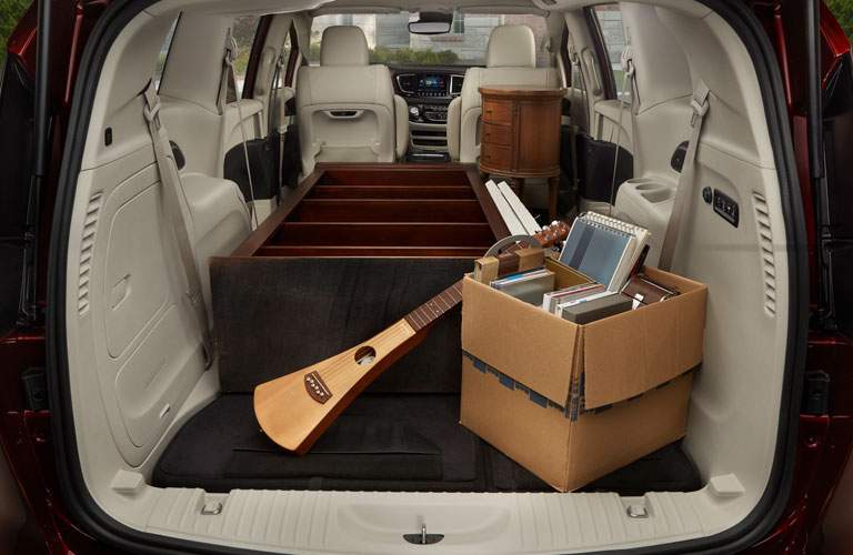rear storage area of the 2018 Chrysler Pacifica filled with a bookshelf and a musical instrument