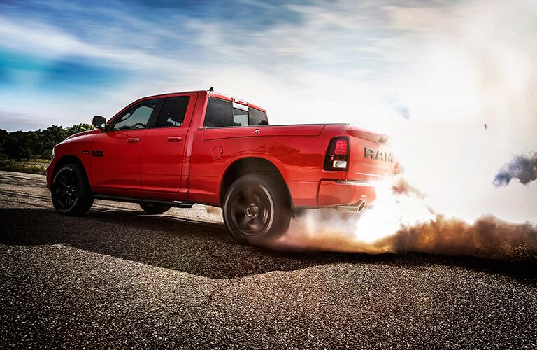 side view of a red 2017 Ram 1500 with dust flying up behind it