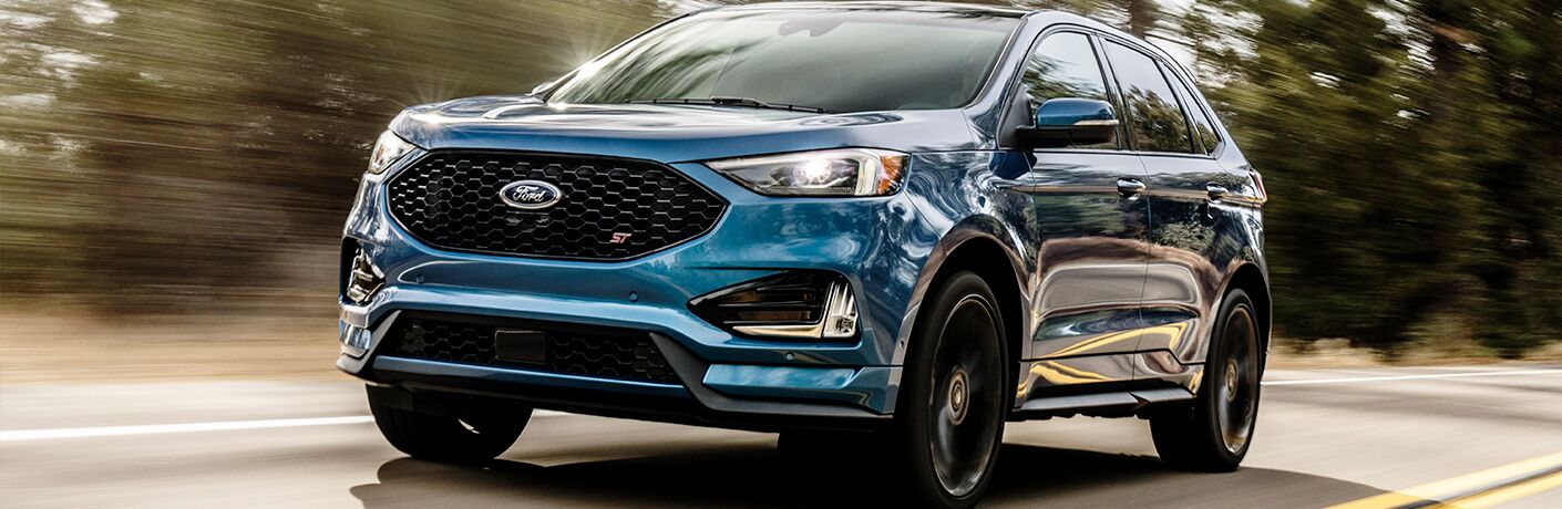 Blue 2019 Ford Edge ST driving on country road