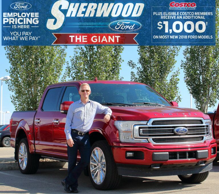 Jerry from Sherwood Ford standing in front of red 2018 Ford F-150