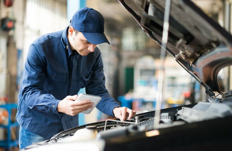 service technician inspecting under hood