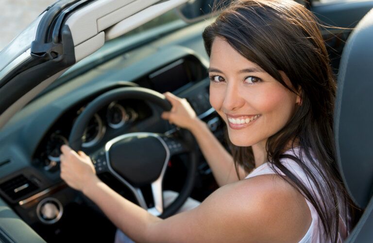 young woman drives home in dream car