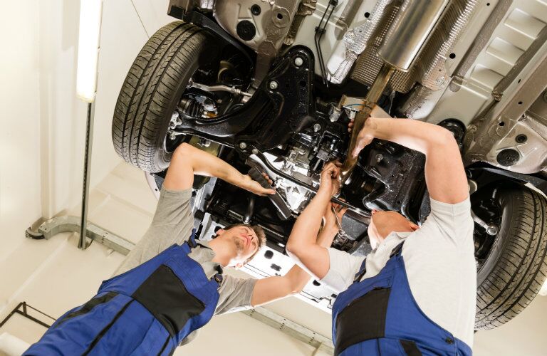 two service technicians inspecting vehicle