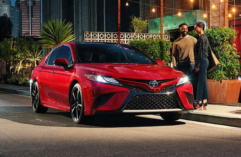 red toyota camry parked, people waiting outside
