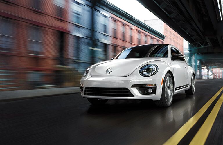 2016 VW Beetle driving under a bridge in the city