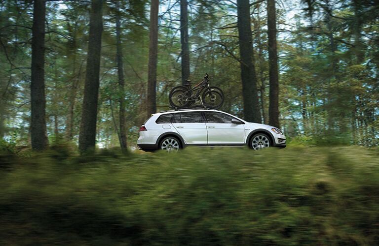 White 2018 Volkswagen Golf Alltrack with bikes mounted to roof