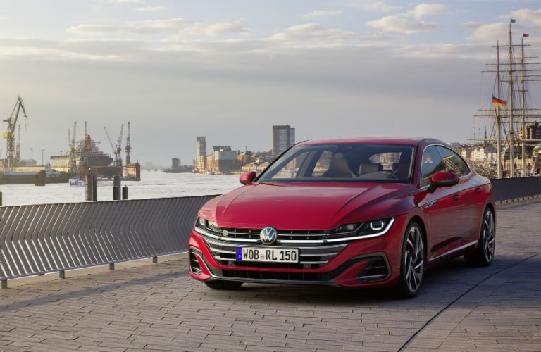 A head-on photo of the 2021 Volkswagen Arteon parked by some ships.