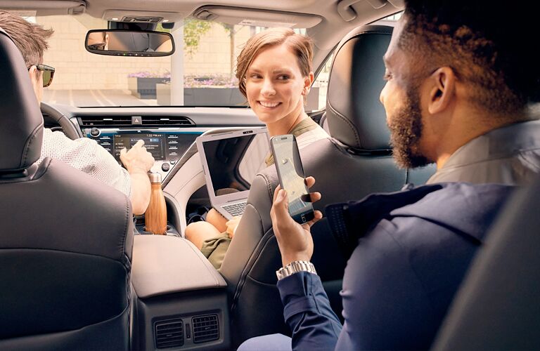 Passengers in the 2019 Toyota Camry using phones and laptops