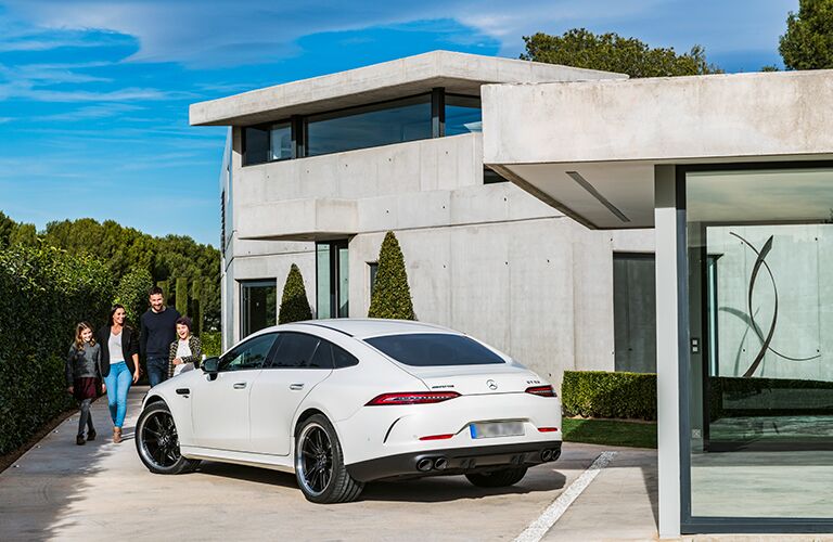 Family walking towards white 2019 Mercedes-AMG® GT Coupe