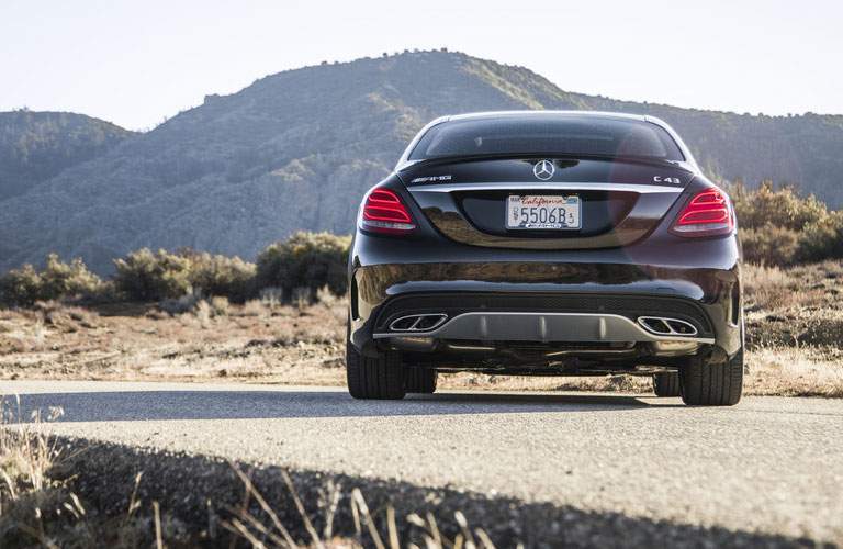 rear view of a black 2018 Mercedes-Benz C-Class parked in front of mountains