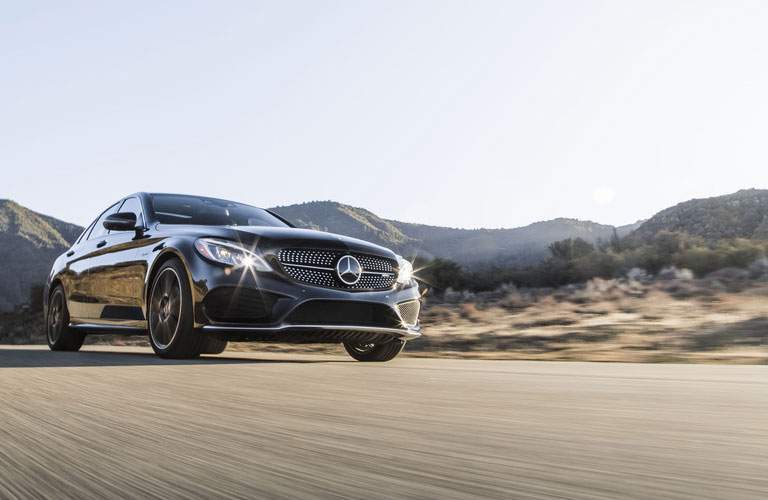 side view of the 2018 Mercedes-Benz C-Class driving in front of mountains