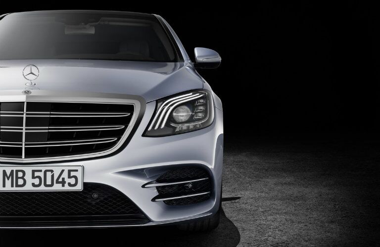 close up shot of a silver Mercedes-Benz S-Class sitting in a dark showroom
