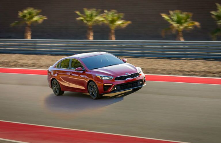 2019 Kia Forte Driving Down Road in Red Coloring