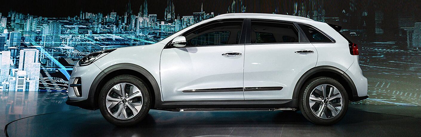A white 2019 Kia Niro sits in profile with a futuristic city in the background.