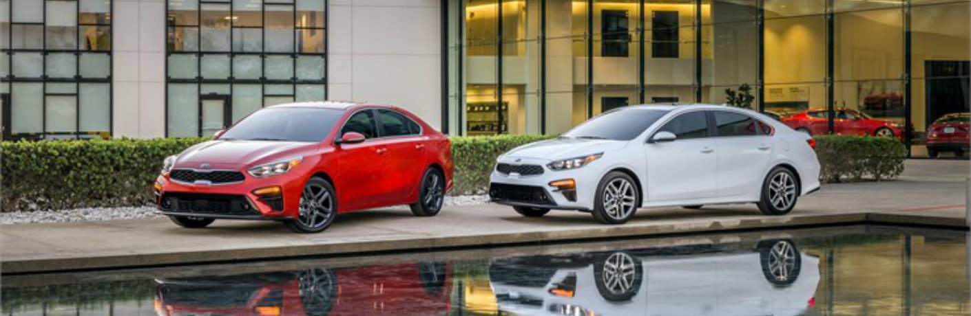 red and white 2019 Kia Forte models parked side by side