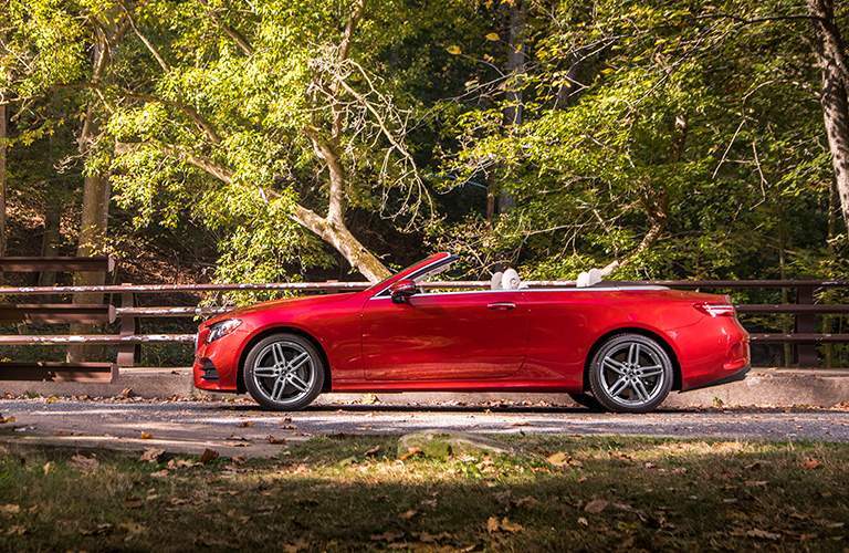 side view of a red 2018 Mercedes-Benz E-Class Cabriolet with the forest in the background