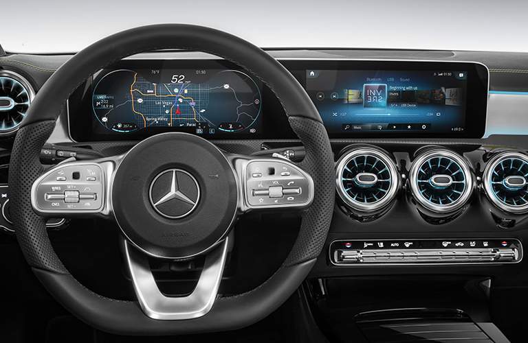 steering wheel and Mercedes-Benz User Experience Infotainment System showing some functions