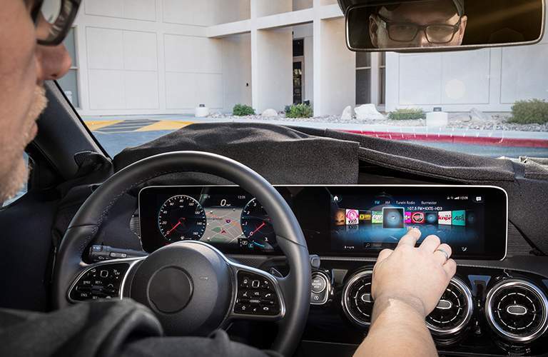 person using the infotainment features on the Mercedes-Benz User Experience Infotainment System on the new touchscreen