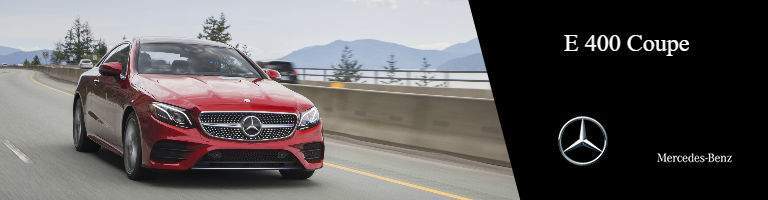 red 2018 Mercedes-Benz E-Class Coupe driving on the road, with a black label on the right