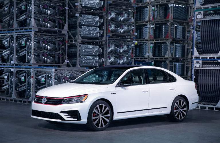 A front left quarter view of a white 2018 VW Passat parked in a factory