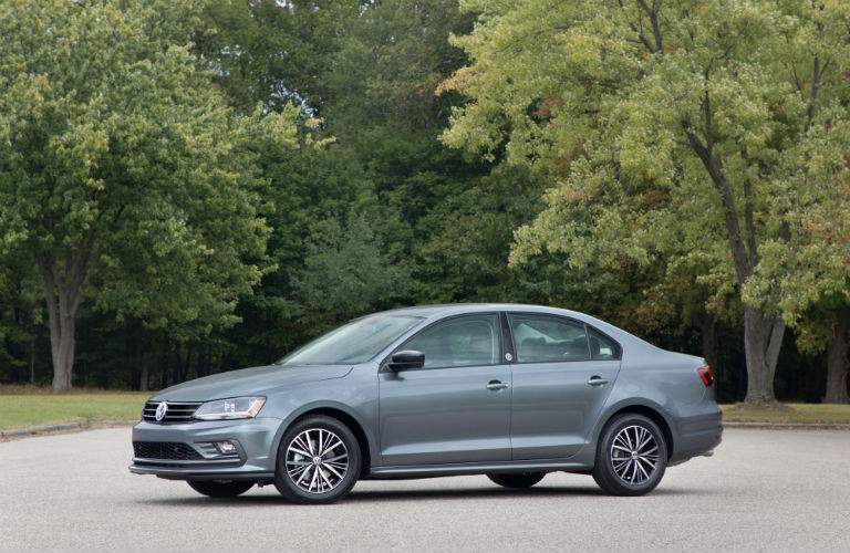 A left profile photo of a gray 2018 Volkswagen Jetta in a parking lot