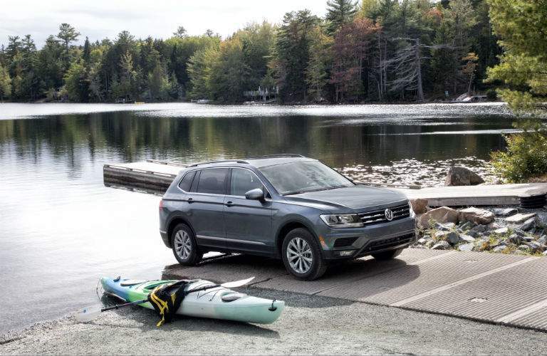 A right profile photo of a 2018 VW Tiguan parked near a lake.