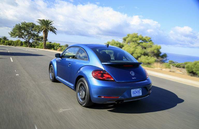 A rear left quarter view of a blue 2018 Volkswagen Beetle