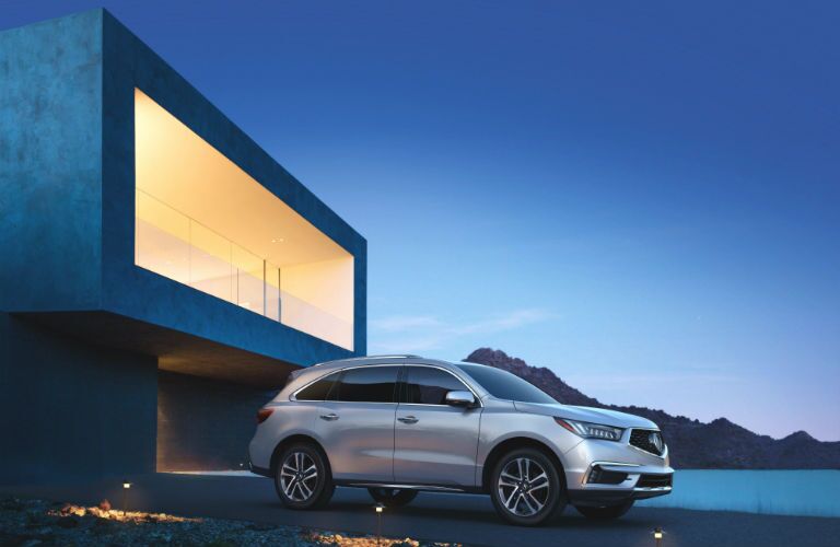 A right profile photo of the 2018 Acura MDX in front of a building.