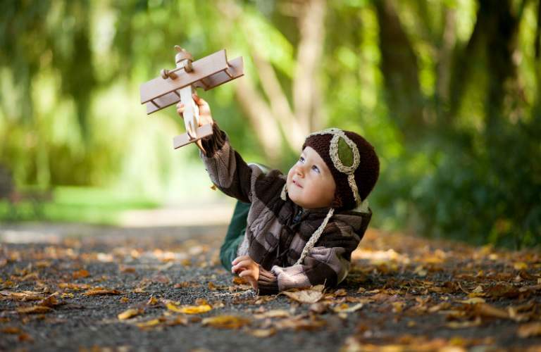 Kid in a park playing with a toy plane