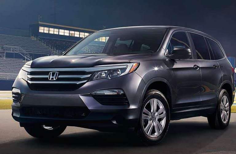 dramatic side view of a 2017 Honda Pilot LX parked in a high school sports stadium