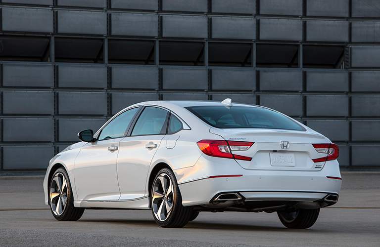 side and rear view of a white 2018 Honda Accord parked in front of a patchwork background