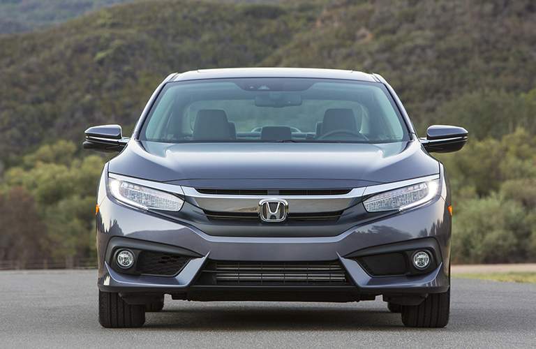 front view of a grey 2018 Honda Civic parked in front of a hill