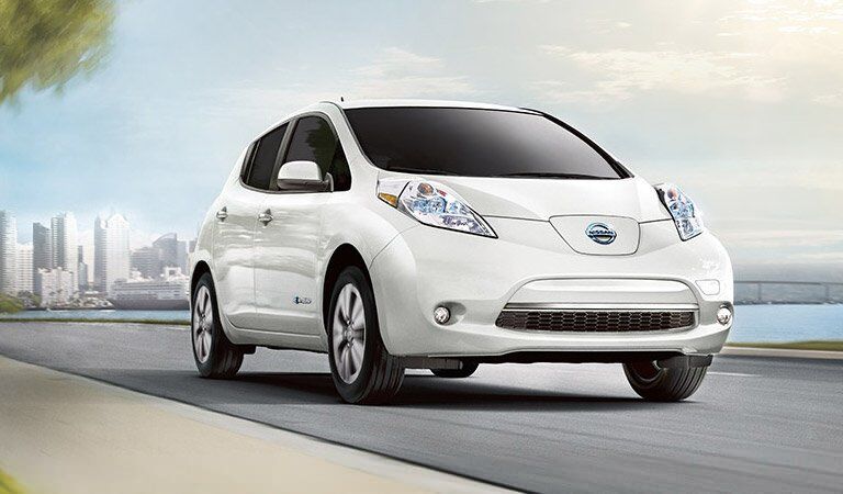 white 2017 Nissan Leaf driving down street