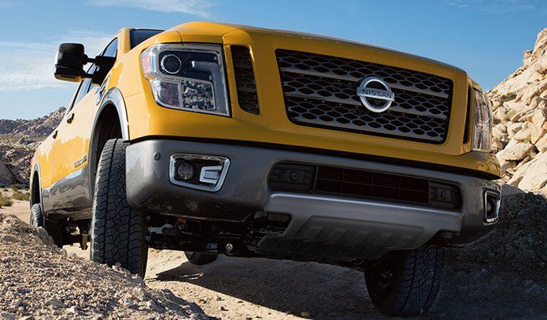 yellow 2017 Nissan Titan XD driving on top of rocks