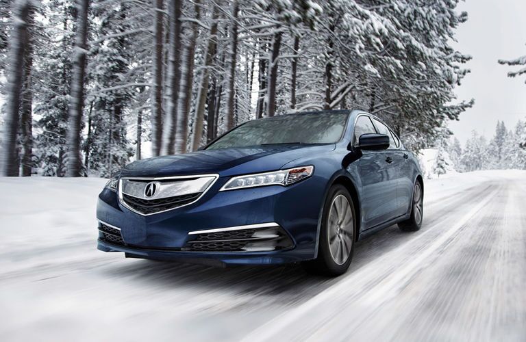 Blue Acura TLX driving through snow
