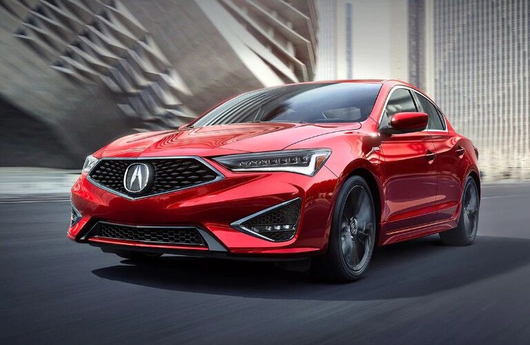 Front driver angle of a red 2019 Acura ILX driving down a road