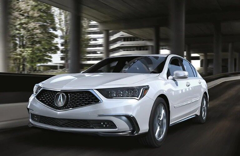 Front driver angle of a white 2020 Acura RLX driving on a road