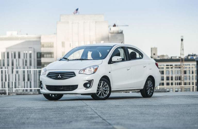 A front left quarter photo of a white 2018 Mitsubishi Mirage G4 in a parking lot