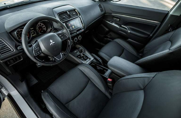 An interior view of the driver's cockpit of the 2018 Outlander Sport including the infotainment system and center gauge cluster