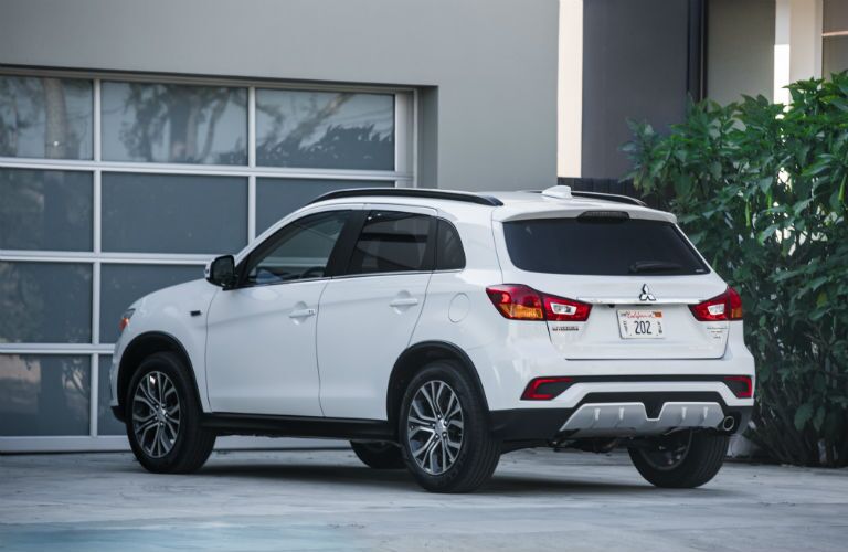A rear left quarter photo of the 2018 Outlander Sport parked in front a garage door.