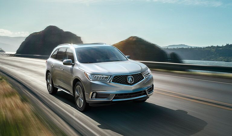 2017 Acura MDX driving by a body of water